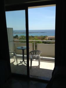 a view of a balcony with a table and a chair at Hotel Jonic in Portopalo