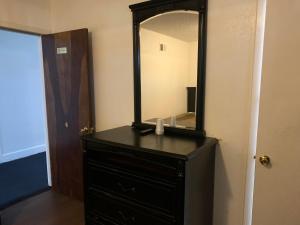 a black dresser with a mirror on top of it at Encore Inn in Inglewood