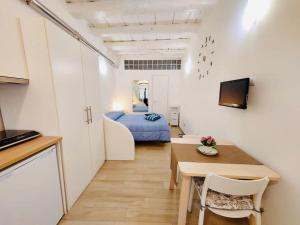 カリアリにあるIl Tesorino di Castello - Cagliari Centro Storicoの小さなアパートメントで、ベッドルーム1室、テーブル、ベッド1台が備わります。