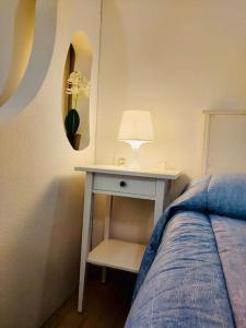 カリアリにあるIl Tesorino di Castello - Cagliari Centro Storicoのベッドルーム1室(ベッド1台、ランプ付きテーブル付)
