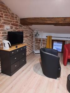 un soggiorno con TV, scrivania e sedia di Mill D'Arx a Château