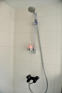 y baño con ducha con cabezal de ducha. en Jono Apartment, en Klaipėda