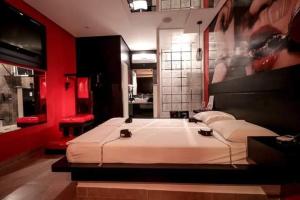 a bedroom with a large bed in a red room at Ápice Motel in Jaguariúna