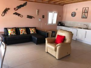 ein Wohnzimmer mit einem Sofa und einem Stuhl in der Unterkunft Vivienda Vacacional Casa Lina in Corralejo