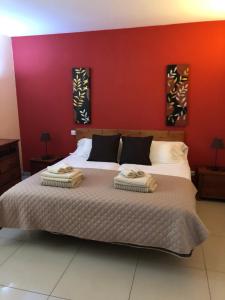 Vivienda Vacacional Casa Lina في كوراليخو: غرفة نوم بسرير كبير وبجدار احمر