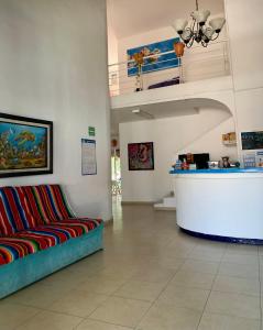 - une salle d'attente avec un canapé et un comptoir dans l'établissement Grand Hostal Playa, à Playa del Carmen