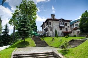 una gran casa de piedra en una colina con escaleras en Petko Takov's House, en Smolyan