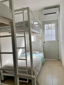 - une chambre avec deux lits superposés et un lit dans l'établissement Grand Hostal Playa, à Playa del Carmen