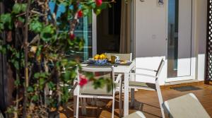 un tavolo con sedie e un cesto di frutta. di Panoramic Seaview Holiday Escape Carvoeiro Algarve a Carvoeiro