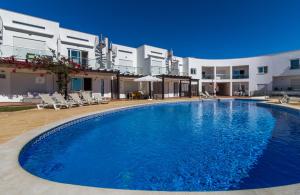 une grande piscine en face d'un bâtiment dans l'établissement Panoramic Seaview Holiday Escape Carvoeiro Algarve, à Carvoeiro