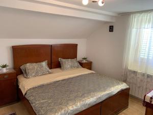 ein Schlafzimmer mit einem großen Bett und einem Fenster in der Unterkunft Domaćinstvo Bakić in Irig