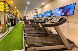 eine Reihe von Laufbändern in einem Fitnessstudio mit Monitoren in der Unterkunft Rose Palace Hotel, Gulberg in Lahore