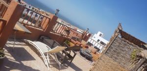a balcony of a building with a table and chairs at Brothers House 2 in Imsouane