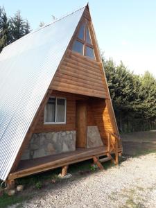 Cabaña de madera pequeña con techo blanco en Cabañas Samay en Funes