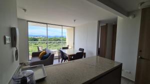 a kitchen with a table and a view of a living room at Apartamento moderno en Puerto Azul Club House in Ricaurte