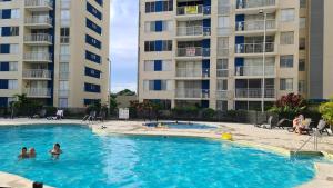 a swimming pool in front of two apartment buildings at Apartamento moderno en Puerto Azul Club House in Ricaurte