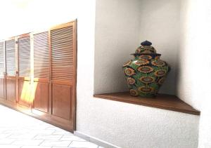 een vaas op een plank naast een raam bij Casa Victoria by Dicasi Vacations in Texcalpan