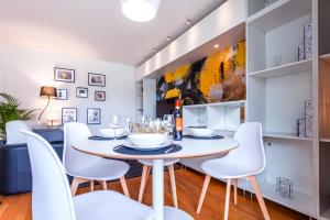 a dining room with a white table and white chairs at ANJA - Top Hôte Paris - 6 Personnes Balcon Parking in Saint-Denis +17 photos