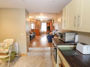 a kitchen with a microwave and a living room at Georges Street in Killala