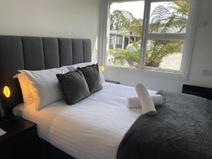 a bedroom with a large white bed with a window at Tullah Lakeside Lodge in Tullah