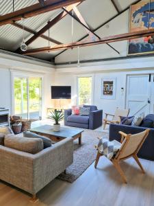 a living room with a couch and a table at Rock Davis Luxury Beachouse - 100mtrs to Beach in Patonga