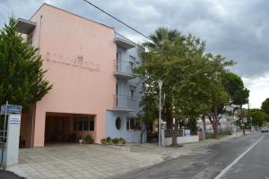 a pink building on the side of a street at Filoxenia Hotel in Volos