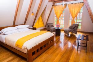 a bedroom with a large bed and two chairs at Amaru Valle Hotel in Urubamba