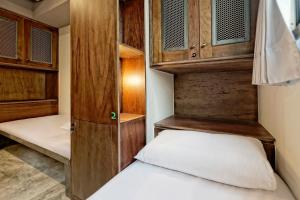 a small bedroom with a bed and wooden cabinets at 拉開門輕旅 Le Passage Hostel in Taipei