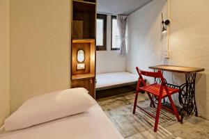 台北的住宿－拉開門輕旅 Le Passage Hostel，配有床、桌子和椅子的房间
