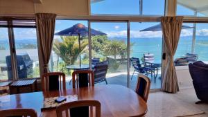 a dining room with a table and a view of the ocean at Kimberley Three - Nelson Waterfront Penthouse in Nelson