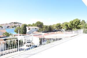 a white balcony with a view of the water at Rooms Bozena in Primošten