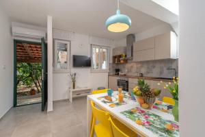 a kitchen and dining room with a table and yellow chairs at House Polus in Trogir