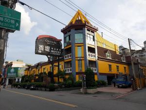 a yellow building with a sign in front of it at Chateau Motel & Spa (Daliao) in Daliao