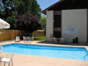 a swimming pool with chairs and a table next to a building at Jamestown Railtown Motel in Jamestown