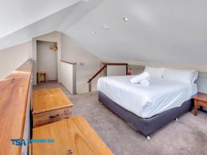 a bedroom with a large white bed and a desk at Ramshead Creek 1 in Thredbo
