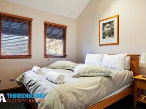a bedroom with a bed with two towels on it at Ramshead Creek 2 in Thredbo