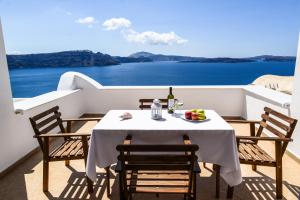 a table with a plate of fruit on a balcony at Top Oia in Oia