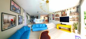 un salon avec des chaises bleues et une télévision dans l'établissement Casa Áurea! A 100 metros da areia de Ponta Negra, com vista deslumbrante do mar, à Natal