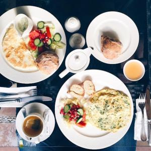 a table with plates of food and cups of coffee at Hotel Fun Residency by Antra Group in Ahmedabad
