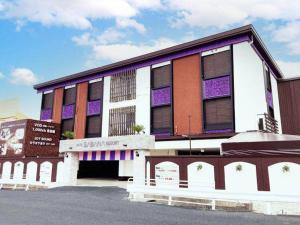 un bâtiment avec de la peinture violette et blanche dans l'établissement ホテルサバナリゾートＡｄｕｌｔ Ｏｎｌｙ, à Kishiwada