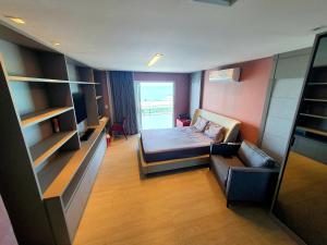 une chambre avec un lit, un canapé et une fenêtre dans l'établissement Casa Áurea! A 100 metros da areia de Ponta Negra, com vista deslumbrante do mar, à Natal 36 autres photos