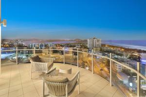 a balcony with chairs and a view of a city at Aqua Vista Resort in Maroochydore