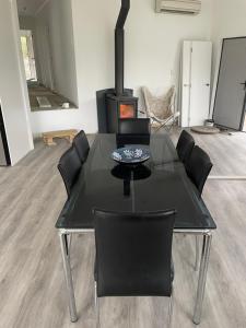 een zwarte eettafel met stoelen en een fornuis bij Private Retreat Central Wanaka 2 Bedroom in Wanaka