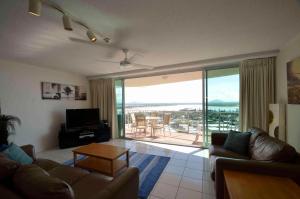 a living room with a couch and a table and a balcony at Chateau Royale Beach Resort in Maroochydore