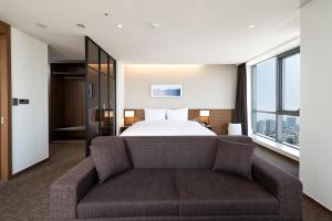 Postel nebo postele na pokoji v ubytování Ramada Encore by Wyndham Busan Haeundae