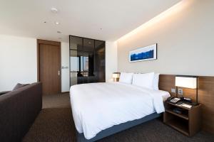 Postel nebo postele na pokoji v ubytování Ramada Encore by Wyndham Busan Haeundae