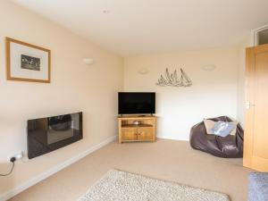 a living room with a tv and a fireplace at Flip Flops in Rhosneigr