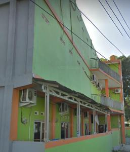 OYO 90706 Kost Alam Jaya Syariah في كراوانغ: مبنى ملون مع شرفات على جانبه