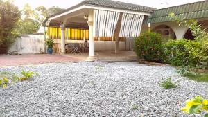 a house with a gravel yard in front of it at AbgZul Homestay in Kota Bharu
