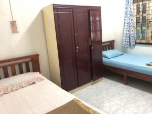 a small room with two beds and a cabinet at AbgZul Homestay in Kota Bharu +4 photos